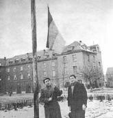  two Armenian DPs hoisting the red-blue-orange flag of the defunct Dashnag government, over Funkerkaserne, Stuttgart, Germany